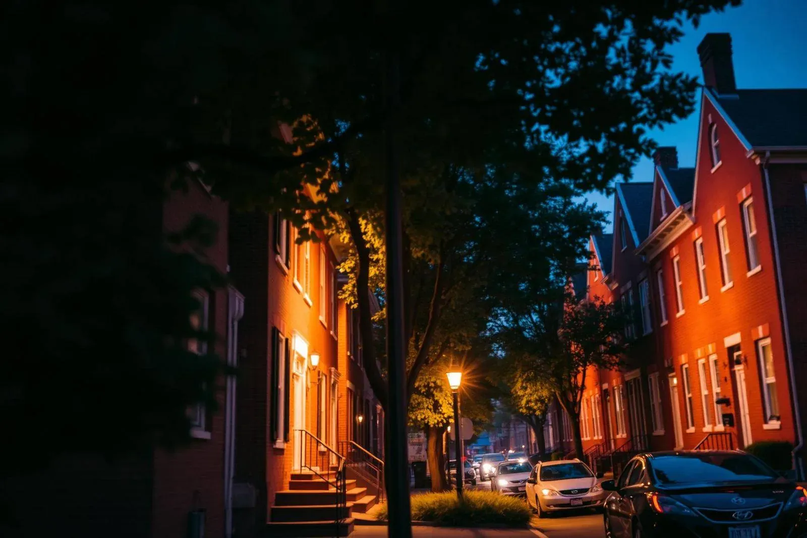 Historic brick row homes on a tree-lined street in Wilmington, Delaware at dusk